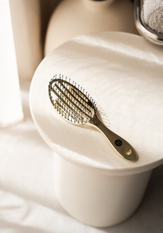 Gouden Supreme borstel van Luxurious Hairextensions, accessoire voor haarverzorging, met glanzende gouden details op een witte achtergrond
