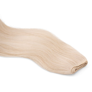 Luxurious Hairextensions Deluxe Triple Weft Pro, 100% menselijk haar, 50cm lange haarextensies op een witte achtergrond.