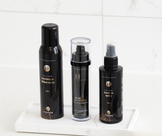 Luxurious-Hairextensions Deluxe Triple Radiance Haarverzorging set met flesjes en haarverzorgingsproducten op witte achtergrond